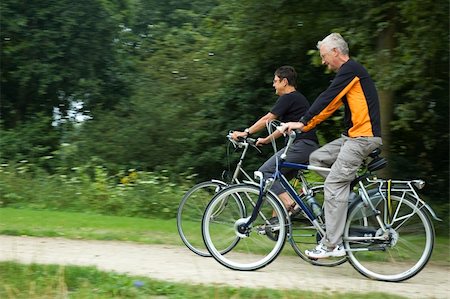 Seniors biking on a sandy path with motion in the picture. Focus is on the woman. Stock Photo - Budget Royalty-Free & Subscription, Code: 400-04961653