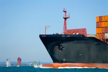 A huge container ship makes its way through a yacht filled waterway Stock Photo - Budget Royalty-Free & Subscription, Code: 400-04963299