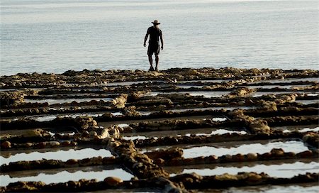 picture of archeologically valuable salt pans on the mediterranean island of gozo with silhouette of fisherman in the background. these saltpans were used thousands of years ago till quite recently to make sea salt for local consumption. Foto de stock - Super Valor sin royalties y Suscripción, Código: 400-04963413