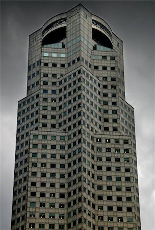 sentinel - An imposing Singapore skyscraper set aganst a threatening sky. Photographie de stock - Aubaine LD & Abonnement, Code: 400-04975753