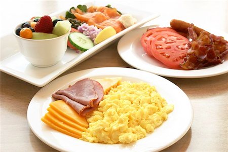 Exotic platter of scrambled eggs, deli beef, ham, sliced turkey & chicken and assorted cheese slices. Sausages, bacon and tomatoes on the side plate and a fruit bowl and salmon salad to complete the meal. Photographie de stock - Aubaine LD & Abonnement, Code: 400-04976876