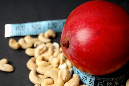 This is an image of a mango, diet tape and some cashew nuts. Fotografie stock - Microstock e Abbonamento, Codice: 400-04979055