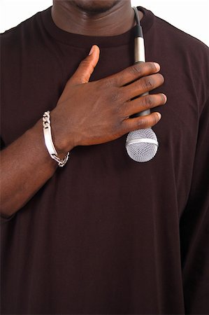This is an image of man with his hand against a microphone to his chest. Fotografie stock - Microstock e Abbonamento, Codice: 400-04979060