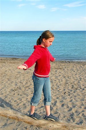 Young girl balancing on log on a sandy beach Stock Photo - Budget Royalty-Free & Subscription, Code: 400-04971785