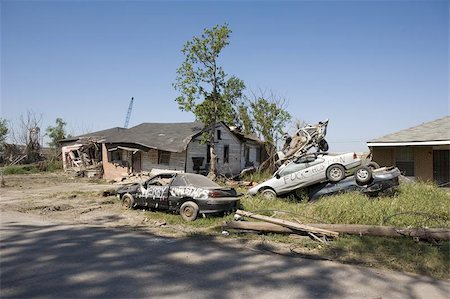 Heavily damaged homes in the Ninth Ward of New Orleans. One block behind these homes is the industrial canal that collapsed during the storm surge of hurricane Katrina. Someone, presumably evacuees returning from Texas  have voiced their frustrations upon these cars.  ( an image edited of the profanity is available ) Stock Photo - Budget Royalty-Free & Subscription, Code: 400-04972182