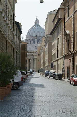 san pietro church - Local street in Rome with the dome of the St. Peter Cathedral in the background Foto de stock - Super Valor sin royalties y Suscripción, Código: 400-04973131