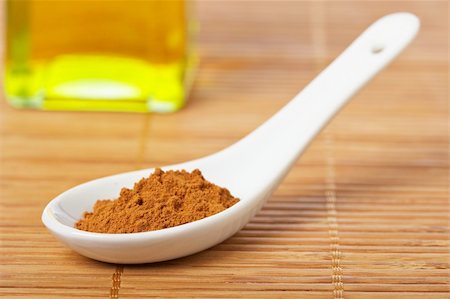 simsearch:400-04047920,k - Cinnamon in the spoon and oil bottle for prepare tasty food with soft shadow in the bamboo mat background. Shallow depth of field Stock Photo - Budget Royalty-Free & Subscription, Code: 400-04984299