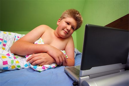 Teenager in bed watching portable DVD player Photographie de stock - Aubaine LD & Abonnement, Code: 400-04984695