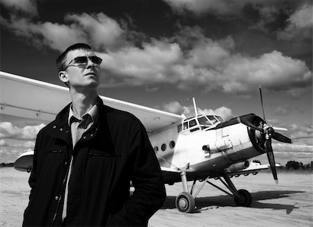 The Young man peers into the sky on background of the white airplane. Fotografie stock - Microstock e Abbonamento, Codice: 400-04985447