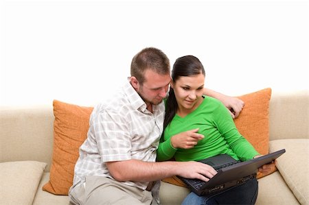 happy couple sitting on sofa together with laptop Stock Photo - Budget Royalty-Free & Subscription, Code: 400-04987497