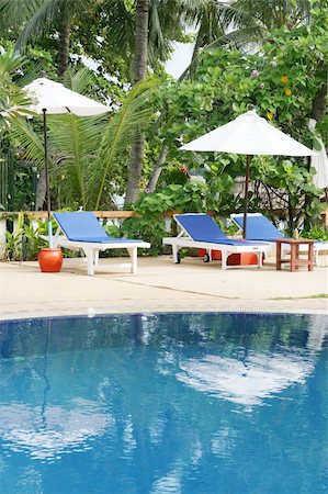 Deck chairs and umbrellas next to a swimming pool. Stock Photo - Budget Royalty-Free & Subscription, Code: 400-04989186