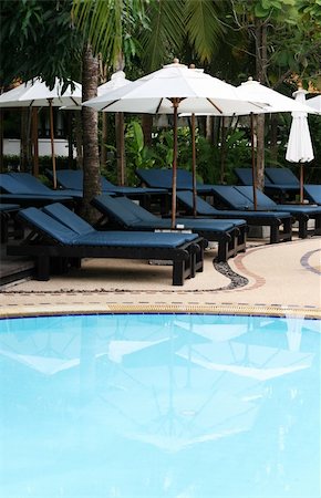 Deck chairs and umbrellas next to a swimming pool. Stock Photo - Budget Royalty-Free & Subscription, Code: 400-04989200