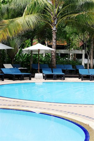 Deck chairs and umbrellas next to a swimming pool. Stock Photo - Budget Royalty-Free & Subscription, Code: 400-04989201