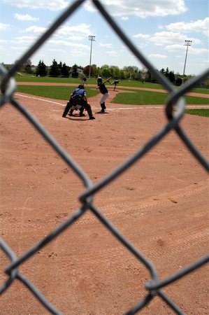 A view through the chain link fence at a baseball game. Stockbilder - Microstock & Abonnement, Bildnummer: 400-04989540