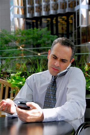 simsearch:400-04717565,k - Portrait of a busy businessman in the city using pda and cell phone Stock Photo - Budget Royalty-Free & Subscription, Code: 400-04981617