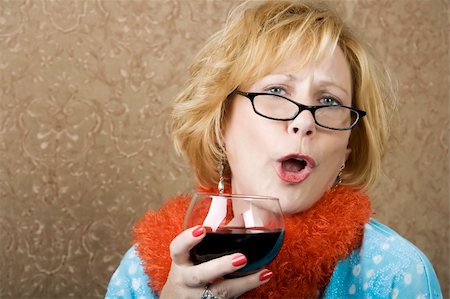 Extroverted woman with a funny expression drinking red wine Foto de stock - Royalty-Free Super Valor e Assinatura, Número: 400-04983869