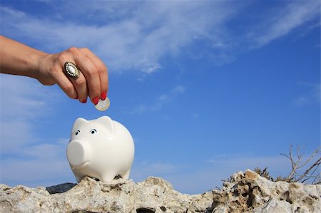 simsearch:400-04255267,k - A woman hand putting a euro coin on a piggy bank Photographie de stock - Aubaine LD & Abonnement, Code: 400-04994202