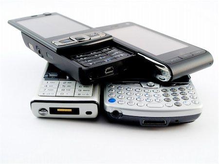 simsearch:400-04356122,k - Stack Pile of Several Modern Mobile Phones PDA Cell Handheld Units Isolated on White Background Stock Photo - Budget Royalty-Free & Subscription, Code: 400-04994780