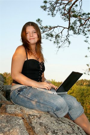 simsearch:400-04196779,k - Female hiker taking a break at the edge of a cliff to check her email on her laptop. Fotografie stock - Microstock e Abbonamento, Codice: 400-04995982