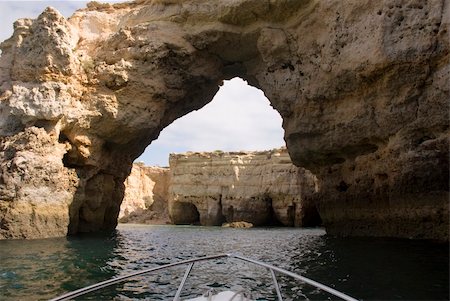 Exploring caves in cliff in littoral of Carvoeiro, Algarve (Portugal) Stock Photo - Budget Royalty-Free & Subscription, Code: 400-04996065