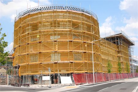 New circular commercial building under construction with scaffolding and safety netting on the exterior. Stock Photo - Budget Royalty-Free & Subscription, Code: 400-04997250