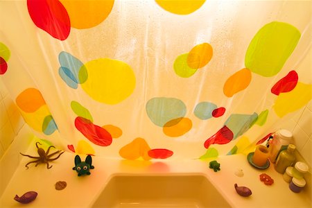 High angle of polka dotted shower curtain and bathtub toys. Fotografie stock - Microstock e Abbonamento, Codice: 400-04997302