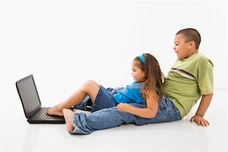Brother and sister putting feet on laptop computer and smiling. Stock Photo - Budget Royalty-Free & Subscription, Code: 400-04997315