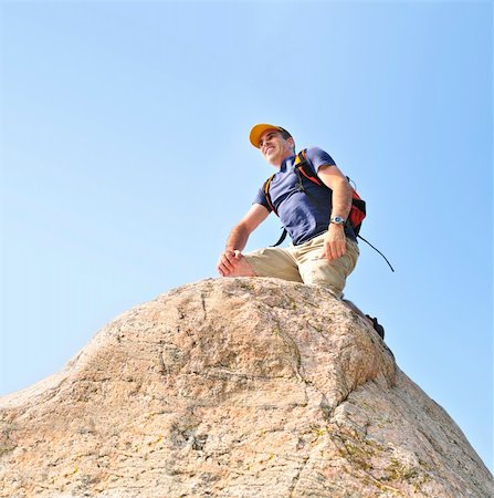 Middle aged man with backpack climbing a rock Stock Photo - Budget Royalty-Free & Subscription, Code: 400-04997334