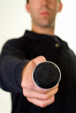 dragon_fang (artist) - A man holding out the microphone for some to talk to sing Stock Photo - Budget Royalty-Free & Subscription, Code: 400-04997481