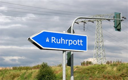 Autobahn direction sign Ruhrpott (Ruhr area, also called Revier or Pott) - the Ruhrgebiet, especially the biggest city Essen, is the european culture capital in 2010 (RUHR.2010 - Kulturhauptstadt Europas) with attractions like Zecke Zollverein or Gasometer Oberhausen. Here are living 5 million people. The Ruhr area had been a big mining area and is now arranged in change. Foto de stock - Super Valor sin royalties y Suscripción, Código: 400-04997517