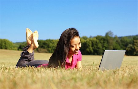 simsearch:6109-06003537,k - Fashionable girl working on laptop in a meadow. Fotografie stock - Microstock e Abbonamento, Codice: 400-04998535