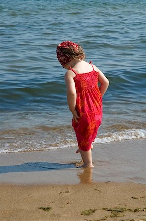 little girl in red dress on the beach Foto de stock - Super Valor sin royalties y Suscripción, Código: 400-04999089