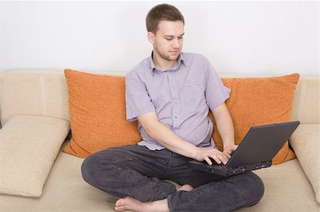 simsearch:400-04999709,k - casual man sitting on sofa with laptop Photographie de stock - Aubaine LD & Abonnement, Code: 400-04999255