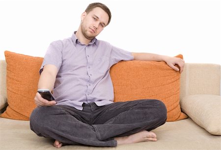 casual man sitting on sofa with remote control Stock Photo - Budget Royalty-Free & Subscription, Code: 400-04999251