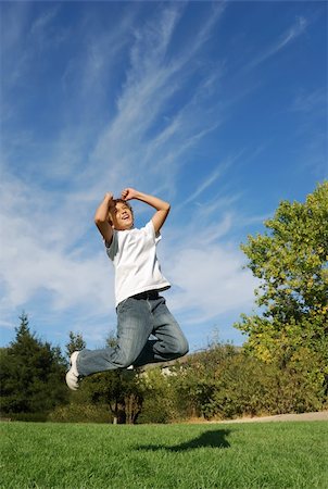 simsearch:400-04982004,k - Boy expressing happiness by jumping in the park Stock Photo - Budget Royalty-Free & Subscription, Code: 400-04999700