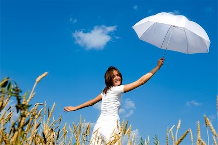 simsearch:400-04662543,k - Happy young girl with umbrella in the field. Smiling face Stock Photo - Budget Royalty-Free & Subscription, Code: 400-04990373