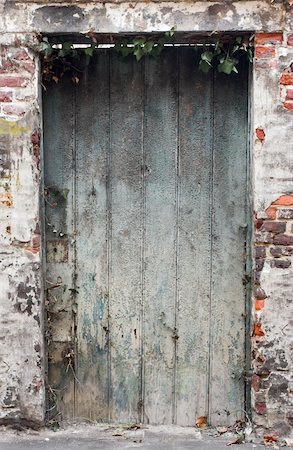 Old weathered deteriorated wooden door in an old red brick wall with plaster spots. Stock Photo - Budget Royalty-Free & Subscription, Code: 400-04990495