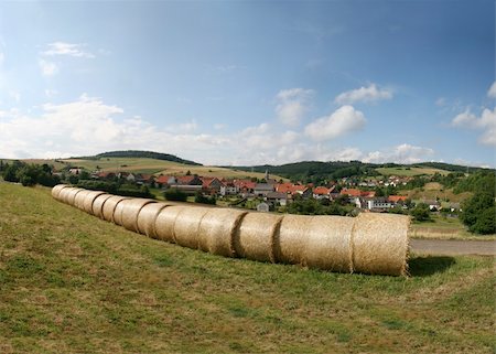 Haybales in a german landscape in the north of Hesse. In the background the village of Mühlbach (Neuenstein) in the Knüll mountains. Stock Photo - Budget Royalty-Free & Subscription, Code: 400-04992387