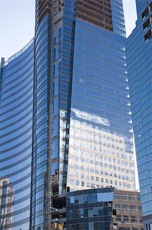dbvirago (artist) - A new curving blue glass office tower under construction with building reflected Fotografie stock - Microstock e Abbonamento, Codice: 400-04992928