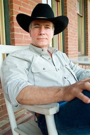 A man with a peaceful relaxed posture, sitting in a rocker on a porch, wearing a cowboy hat. Stock Photo - Budget Royalty-Free & Subscription, Code: 400-04993600