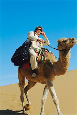 Man with mobile phone riding camel in desert Stock Photo - Budget Royalty-Free & Subscription, Code: 400-04993789