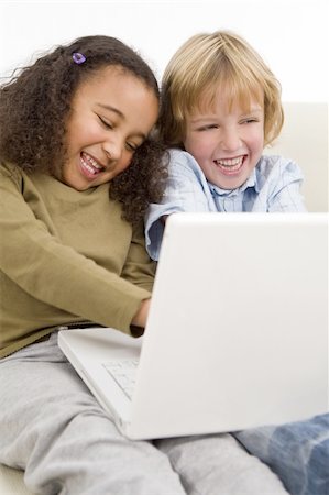 simsearch:400-04575374,k - Two young children having fun on a laptop computer while sitting on a settee Stock Photo - Budget Royalty-Free & Subscription, Code: 400-05005795