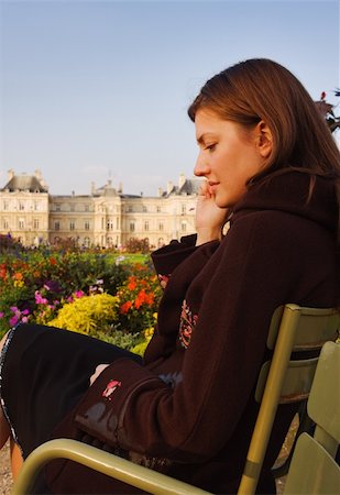 Pretty young woman speaking on her mobile phone while sitting in Luxembourg garden (Paris) in sunset. Unsharp Luxembourg palace in background. Photographie de stock - Aubaine LD & Abonnement, Code: 400-05006481