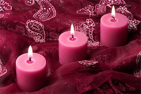 simsearch:400-04715832,k - Three pink candles on a rich ornate purple cloth. Fotografie stock - Microstock e Abbonamento, Codice: 400-05006531