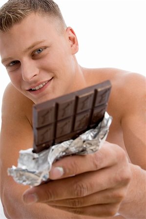 physical fit food - smiling muscular guy showing chocolate on an isolated background Stock Photo - Budget Royalty-Free & Subscription, Code: 400-05007285