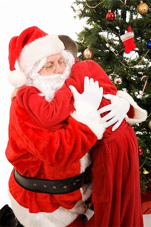 simsearch:400-04636742,k - Santa Claus getting a big hug from a child on Christmas morning.  White background. Foto de stock - Royalty-Free Super Valor e Assinatura, Número: 400-05008642