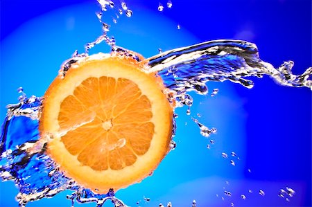 simsearch:400-04552087,k - Close up view of sliced orange piece getting splashed with water Foto de stock - Royalty-Free Super Valor e Assinatura, Número: 400-05009647