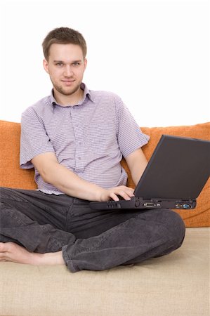 simsearch:400-04999709,k - casual guy sitting on sofa with laptop Photographie de stock - Aubaine LD & Abonnement, Code: 400-05000101