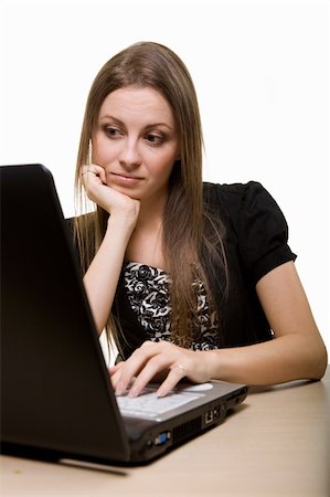 Attractive young brunette woman in business suit sitting at a desk typing on a computer keyboard and with a bored expression looking at screen Stock Photo - Budget Royalty-Free & Subscription, Code: 400-05002360