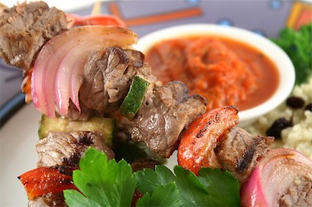simsearch:400-08070549,k - Beef kebabs and currant couscous with harissa sauce. Stockbilder - Microstock & Abonnement, Bildnummer: 400-05002829